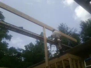 Carpenter setting a ridge beam over a new addition frame — Ice Dam Removal by Roofing Brothers in Sunset