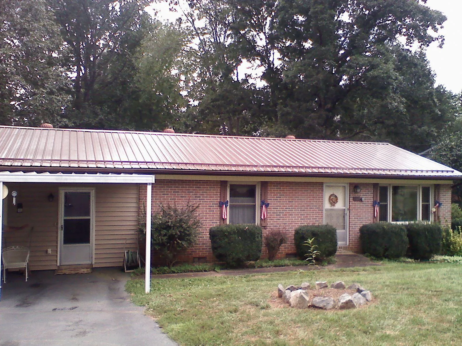Bronze metal roof and carport on a brick ranch home — Roof Repair work by our crew in Sunset